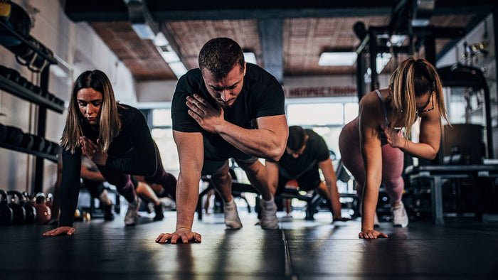 Grupo de personas realizando ejercicio mostrando entrenamiento de fuerza y estabilidad.