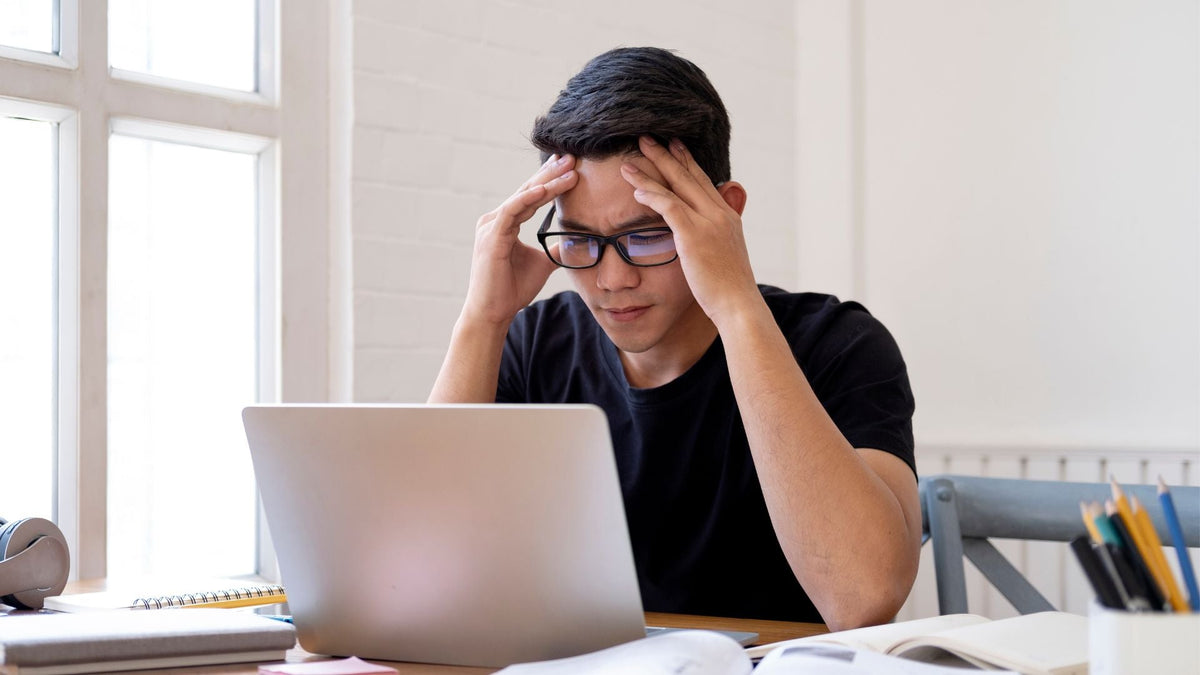Hombre intentando estar concentrado frente a su computador, mostrando signos de cansancio o dificultad para mantener el enfoque.
