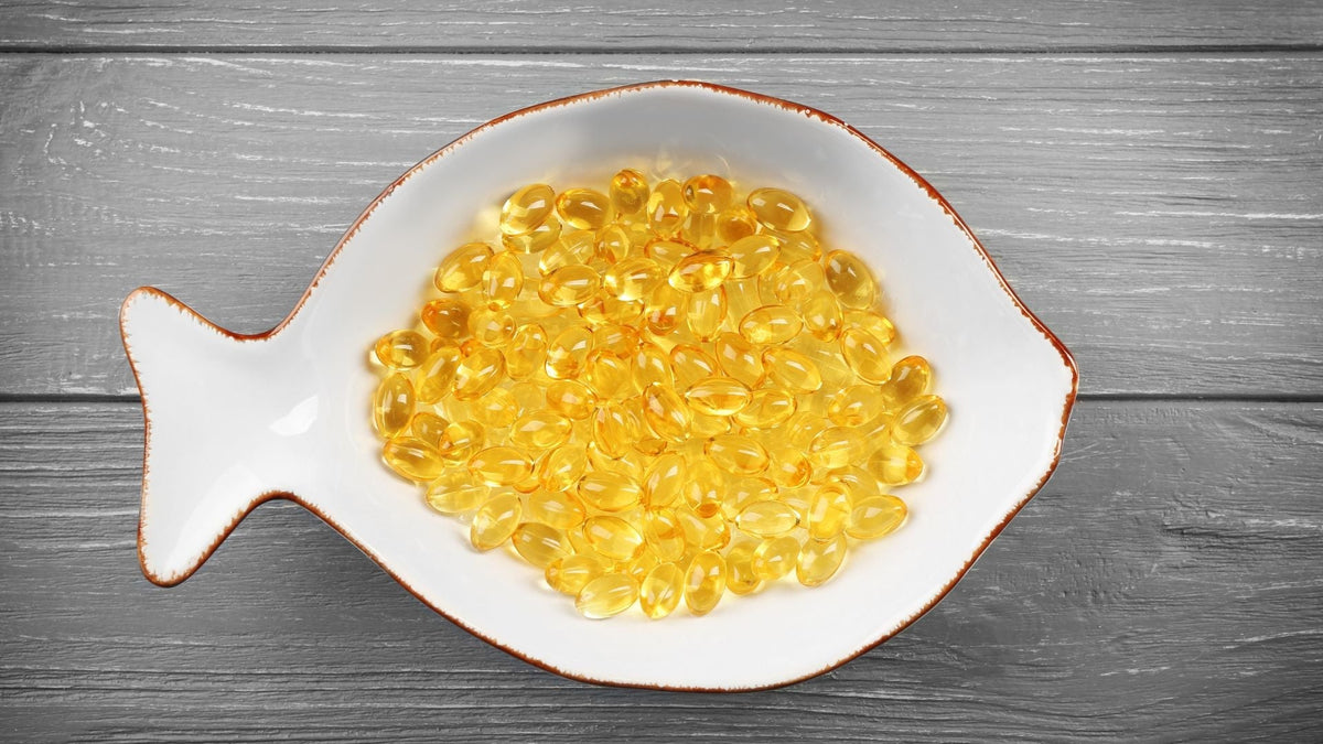 Cápsulas de aceite de hígado de bacalao en un recipiente con forma de pez 
