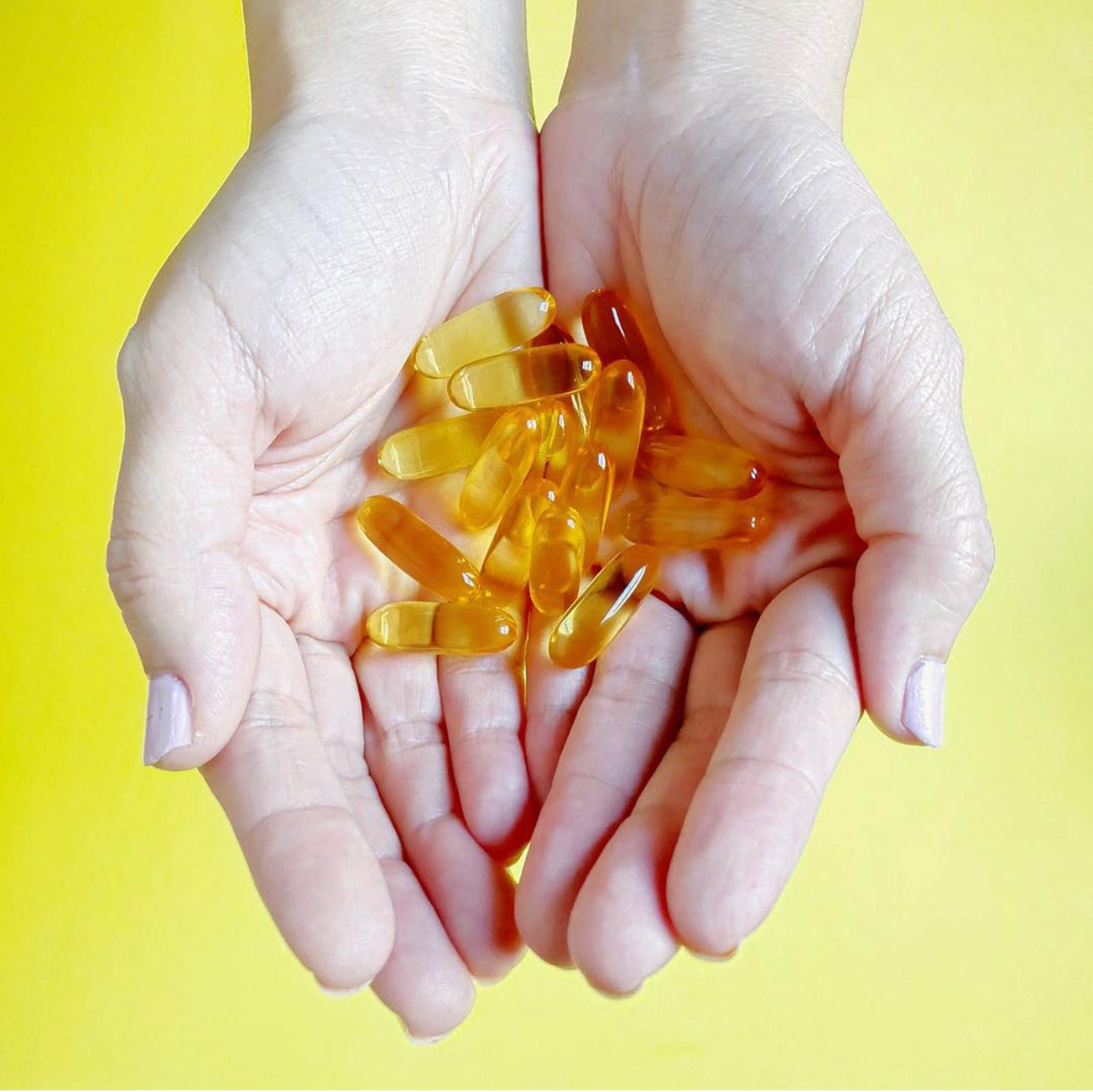 Manos con cápsulas blandas de Omega 3 Ultimate 2x, Ortomolecular Chile