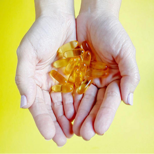 Manos con cápsulas blandas de Omega 3 Ultimate 2x, Ortomolecular Chile