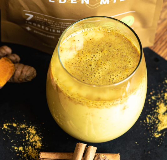 Vaso de batido con Golden Milk, bolsa Astral de fondo y cúrcuma, jengibre y canela, Ortomolecular Chile 