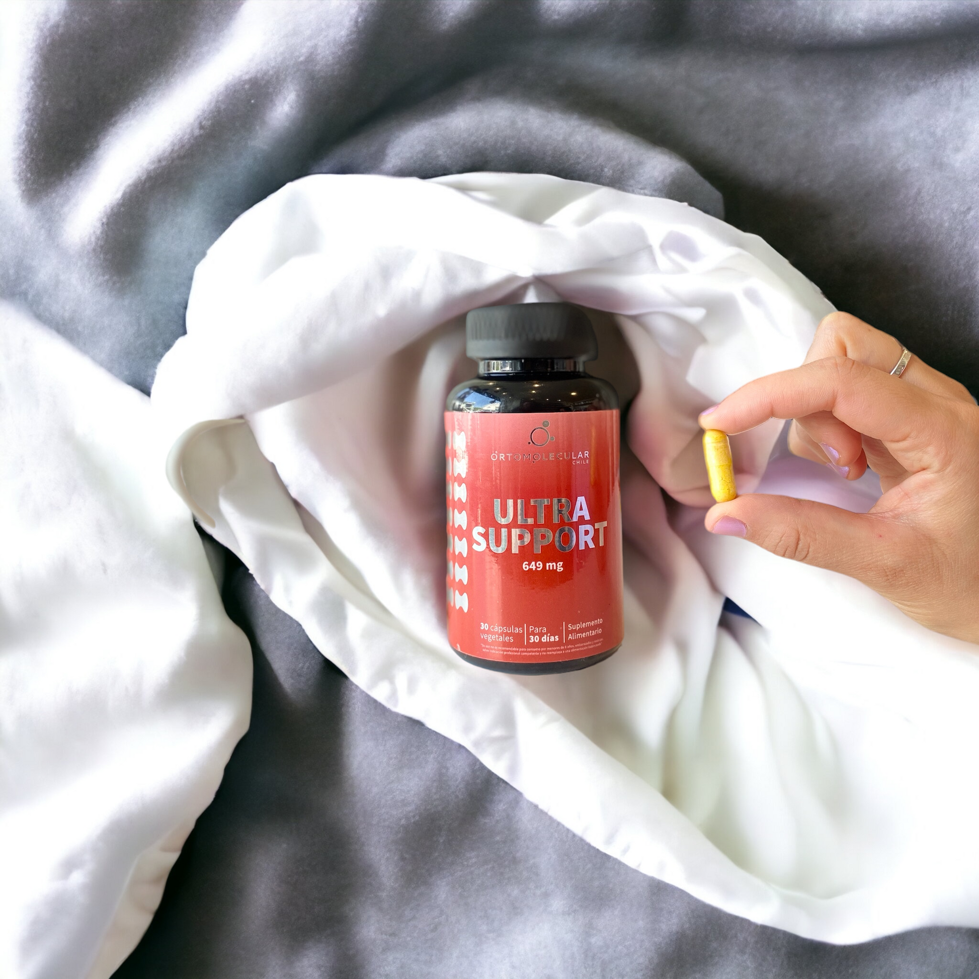 Frasco de Ultra Support, 30 cápsulas con mano sosteniendo una cápsula, Ortomolecular Chile