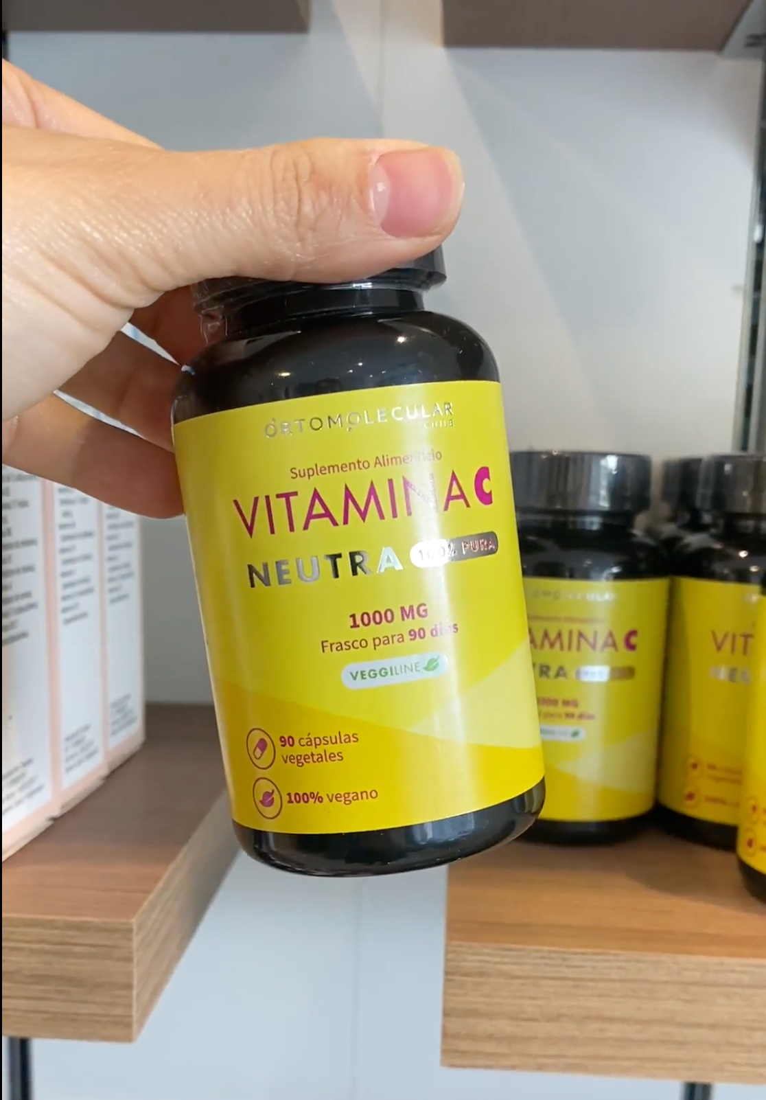 Mano con frasco Vitamina C Neutra 1.000 mg, 90 cápsulas, Ortomolecular Chile 