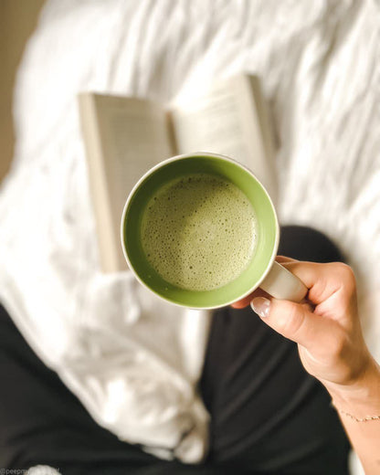 Taza con goldenmilk matcha junto a un libro de forma relajada, ortomolecular chile